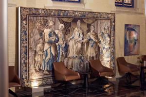 a large tapestry hanging on a wall with chairs at L'Hermitage Gantois, Autograph Collection in Lille