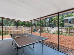 une table de ping-pong dans une cour arrière couverte dans l'établissement Spacious Condo Pet Friendly Ping Pong Table, à Gainesville