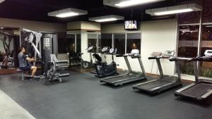 a gym with several treadmills and machines in a room at Apartment Thamrin City 1 Bedroom near Tanah Abang in Jakarta