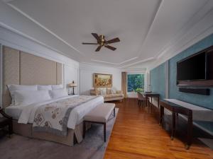 a bedroom with a large bed and a flat screen tv at InterContinental Bali Resort, an IHG Hotel in Jimbaran