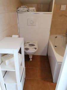 un bagno con un water, una vasca e un lavandino di habitación con techo inclinado y vista al mar a Teulada