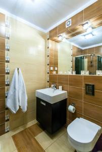 łazienka z umywalką, toaletą i lustrem w obiekcie Apartament Tit Aquarius Spa w Kołobrzegu +28 zdjęć