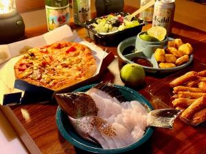 a table with a pizza and other dishes of food at ulala hometown - Vacation STAY 09297v in Kagoshima