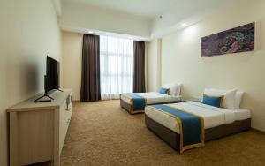 um quarto de hotel com duas camas e uma televisão de ecrã plano em Zecon Hotel em Kuala Lumpur