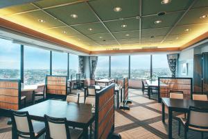 a restaurant with tables and chairs and large windows at Kanazawa Kokusai Hotel in Kanazawa