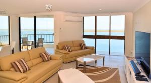 a living room with a couch and a table at Broadwater Shores Waterfront Apartments in Gold Coast