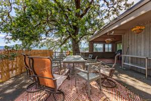 eine Terrasse mit Stühlen und einem Tisch und einem Baum in der Unterkunft Inventor's Cottage 30 Night Minimum home in Underwood
