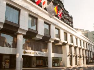 un bâtiment avec des drapeaux sur son côté dans l'établissement Rose Hotel Yokohama, The Distinctive Collection By WORLDHOTELS, à Yokohama