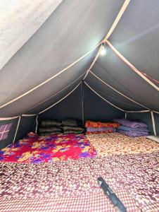 una habitación con una tienda de campaña con una cama en ella en Kedar Tent House en Kedārnāth