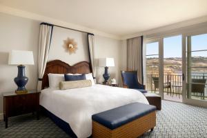 um quarto de hotel com uma cama grande e uma varanda em Terranea Resort em Rancho Palos Verdes