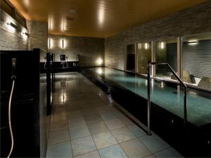 a large swimming pool in a building with a swimming pool at Village Kyoto close by Shijo Omiya station in Kyoto