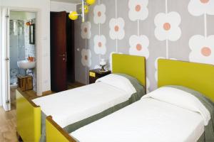 duas camas num quarto com flores na parede em Agriturismo Scribano em Prepotto
