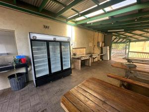 a room with a table and benches in a building at Kalbarri Backpackers Hostel in Kalbarri