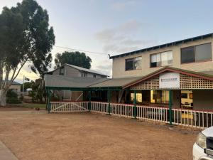 a building with a fence in front of it at Kalbarri Backpackers Hostel in Kalbarri