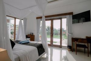 una camera da letto con un letto, una scrivania e una finestra di Namika Villas Ubud ad Ubud
