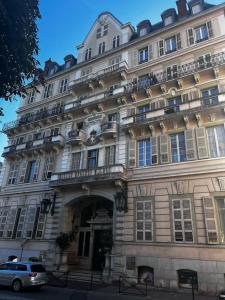 un bâtiment avec une voiture garée devant dans l'établissement Appartement de charme dans le residence historique du Grand hotel, à Aix-les-Bains