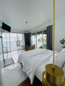 a bedroom with a large bed with a view of the ocean at Bintana Sa Paraiso in Mambajao