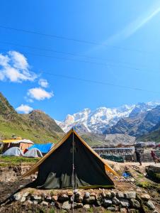 ein Zelt auf einem Hügel mit Bergen im Hintergrund in der Unterkunft Kedar Tent House in Kedārnāth
