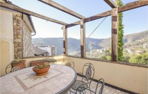 a balcony with a table and a view of the mountains at 2 Bedroom Awesome Home In Vado Ligure in Vado Ligure