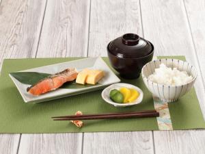 a plate of sushi and a bowl of rice and chopsticks at Hotel Rocco (Adult Only) in Nara