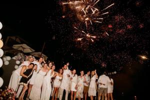 a group of people in white dresses standing in front of fireworks at Bintana sa Paraiso Binunsaran in Mambajao +277 photos
