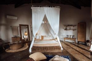 a bedroom with a bed with a mosquito net at Bombora Siargao in General Luna