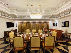 a conference room with a table and chairs and a chandelier at Mayfair Palm Beach Resort in Gopālpur