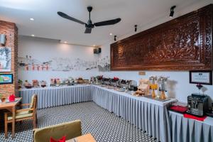 a dining room with a table with aasteryasteryasteryasteryasteryasteryasteryastery at Home Chic Hotel in Phnom Penh