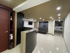 a kitchen and living room with a couch and a counter at Hotel Rialto Suite in Pasto