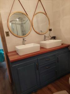 a bathroom with two sinks and two mirrors at Rincón nevado in Coñaripe