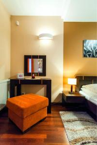 sypialnia z łóżkiem, stołem i otomaną w obiekcie Apartament Tit Aquarius Spa w Kołobrzegu
