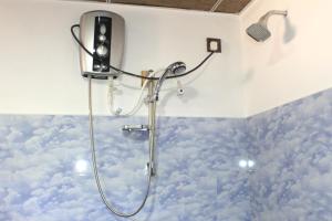 una doccia con nuvole dipinte sul muro di un bagno di Sigiri Sanu Villa a Sigiriya
