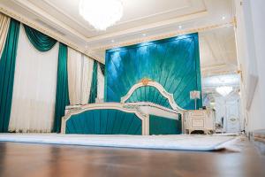 een kamer met een podium met een bed erin bij KANGURT Grand Hotel in Doesjanbe