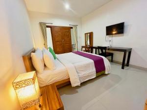 a bedroom with a bed and a desk with a desk at Pererenan nengah guest house canggu in Canggu
