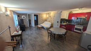 a kitchen with red cabinets and a table and chairs at Maisonnette de Villiers gare à 5 minutes in Saint-Fargeau-Ponthierry +2 photos