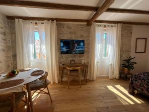 - un salon avec une table et une télévision dans l'établissement Casa di Luna Rovigno, à Rovinj