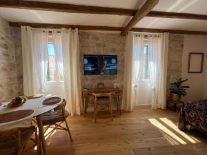 a living room with a table and a tv at Casa di Luna Rovigno in Rovinj