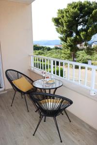 patio z 2 krzesłami i stołem na balkonie w obiekcie Apartments Larus w mieście Cavtat