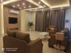 a living room with two couches and a tv at Hacienda bay in El Alamein