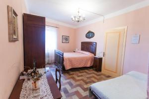 a bedroom with two beds and a table and a clock at Montelupone Bed & Breakfast in Montelupone