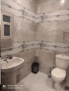 a bathroom with a toilet and a sink at Hacienda bay in El Alamein