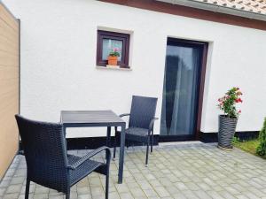 un patio con 2 sedie, un tavolo e una finestra di Pension & Wirtshaus ''Tun Eikkoter'' Kobel II a Wieck