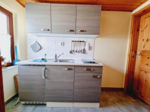 una cucina con armadi in acciaio inossidabile e lavandino di Pension & Wirtshaus ''Tun Eikkoter'' Kobel II a Wieck 1 altra foto