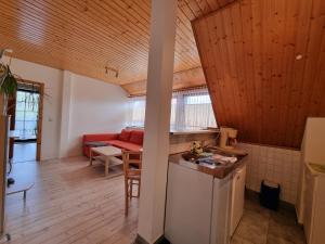 a kitchen and living room with wooden ceilings and a table at Pension & Wirtshaus ''Tun Eikkoter'' Eichkater in Wieck