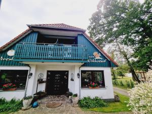 a blue and white building with a balcony at Pension & Wirtshaus ''Tun Eikkoter'' Eichkater in Wieck