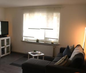 a living room with a couch and a window at Ferienhaus Luna in Dornum
