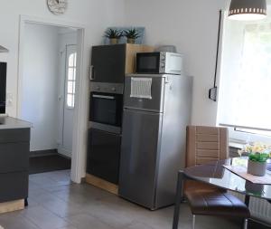 a kitchen with a refrigerator and a table at Ferienhaus Luna in Dornum