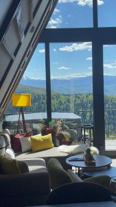 a living room with a couch and a large window at Sarajevo Luxury Chalets in Sarajevo