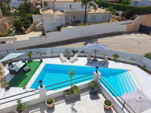 uma vista superior de uma piscina com guarda-sóis em Amigos para Sempre - Casa de Hóspedes em Ferragudo