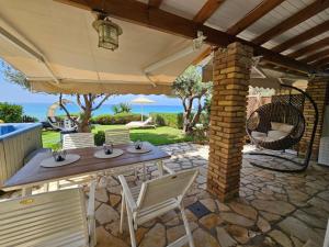 patio ze stołem i krzesłami pod parasolem w obiekcie Beachfront House 13 ,Glyfada w mieście Glifada